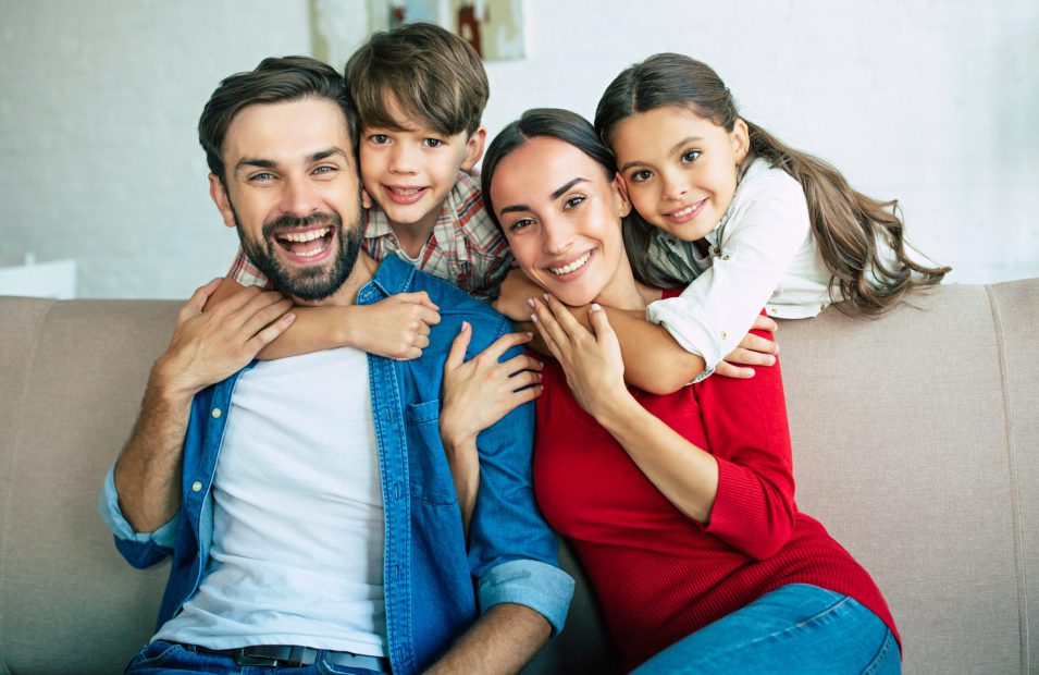 Young happy family relax together at home smiling and hugging Dental services in Little Current
