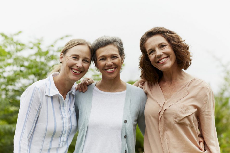 Happy mature women standing in park About our dental care